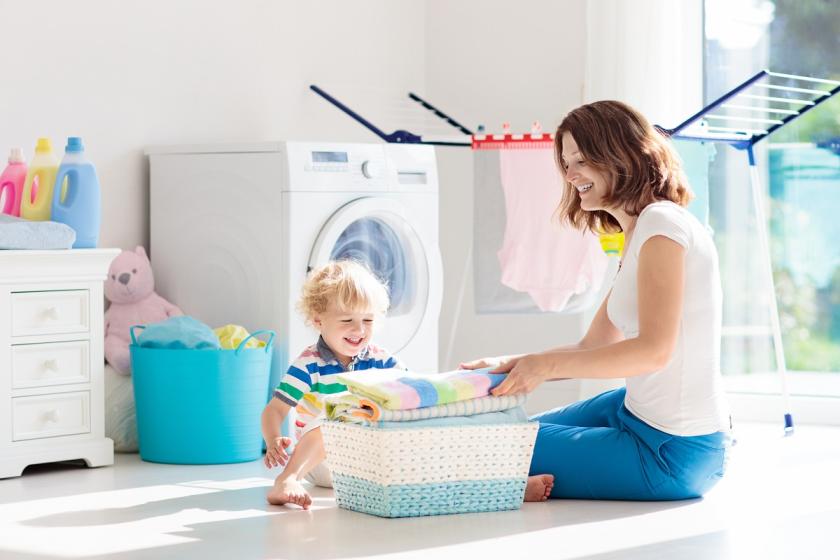 žena s dítětem u pračky